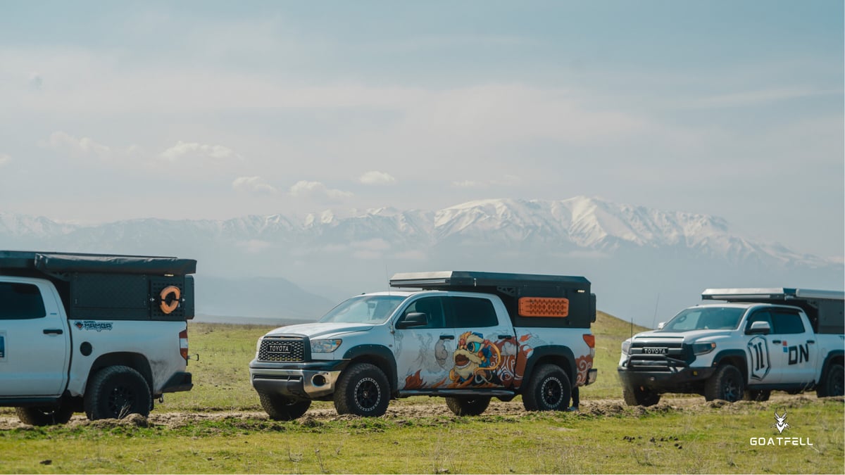 convoy of three demountable camper trucks in the wilderness