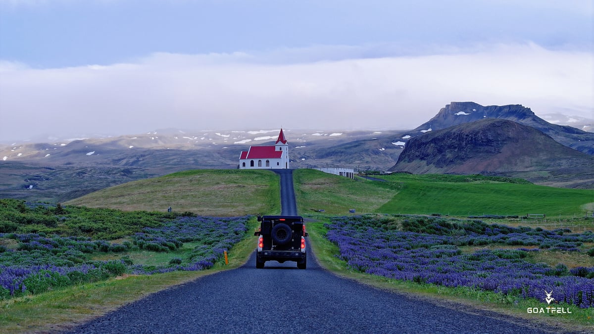 rear view of a demountable camper truck driving down a long road in the countryside